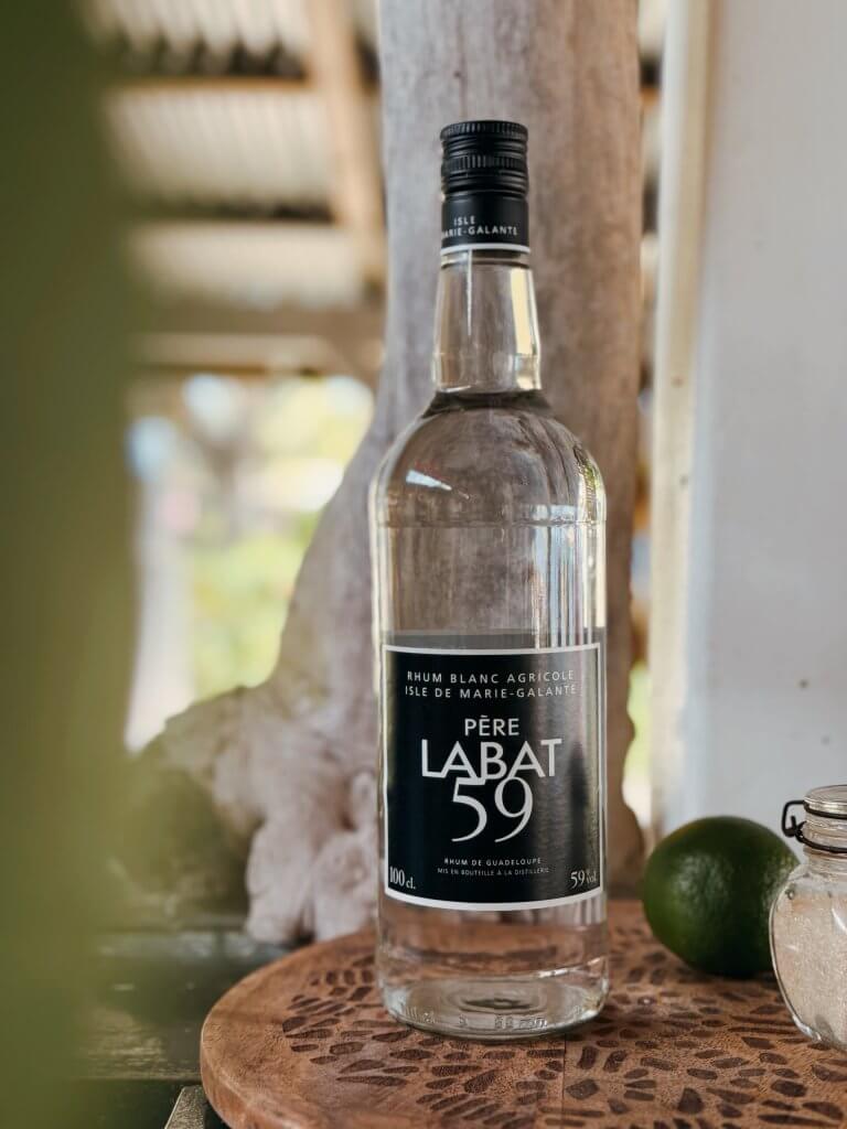 Bouteille de rhum blanc agricole Père Labat 59 accompagnée d'un citron vert et de sucre pour un ti-punch